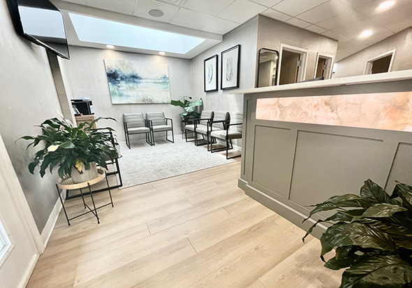 The image shows an interior view of a dental clinic reception area, featuring a sign that reads HOFFER DENTAL CARE and a reception desk with a countertop.